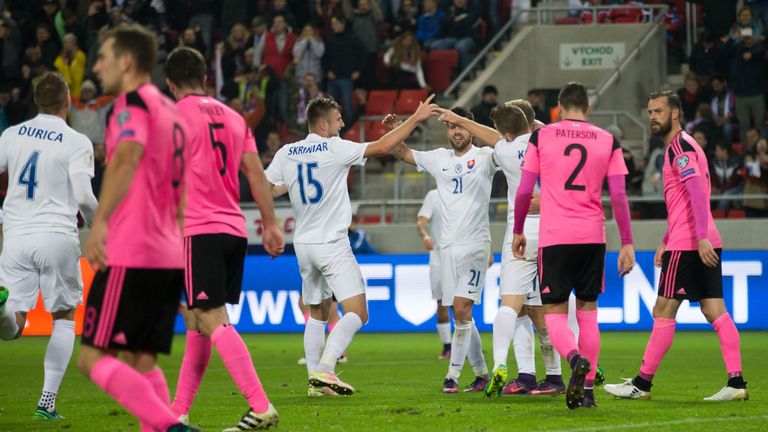 Scotland's Steven Fletcher (R) and Callum Paterson (2ndR) walk past Slovakia's players celebrating their third goal