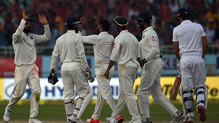 Indian captain Virat Kohli (L) celebrates the wicket of England captain Alastair Cook (R) with Ravindra Jadeja (C) and teammates during the fourth day of t