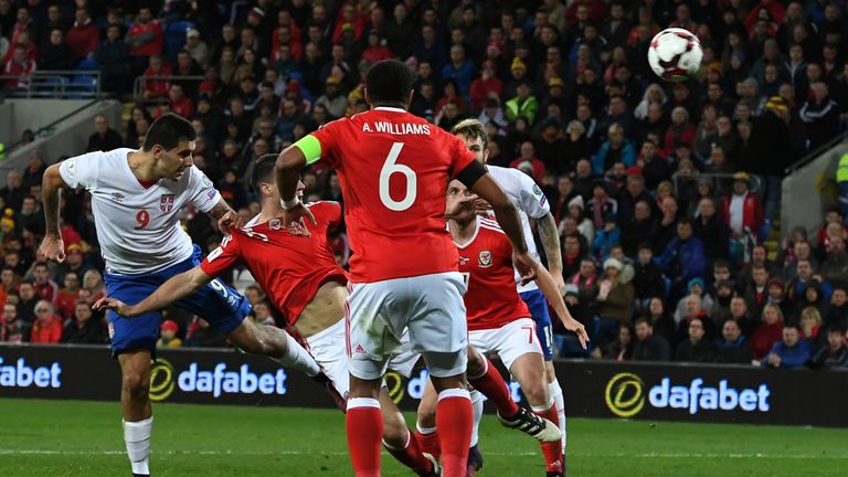 Serbia's striker Aleksandar Mitrovic (L) scores their first goal with this header during the World Cup 2018 qualification match between Wales and Serbia at