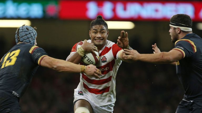 Amanaki Mafi takes on Jonathan Davies (L) and Wales' prop Nicky Smith