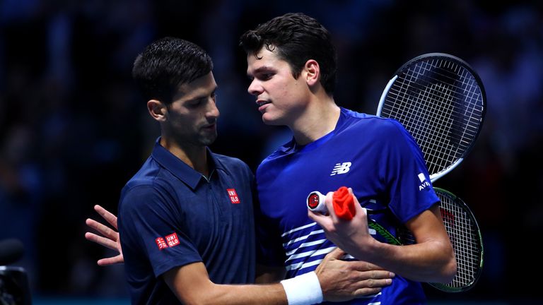 Novak Djokovic of Serbia speaks with Milos Raonic of Canada at the net after their men's singles match
