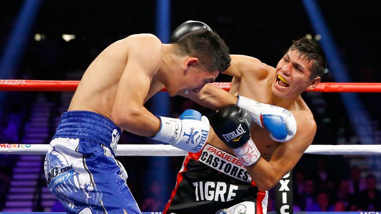 Jose Cayetano (R) throws a right at Leo Santa Cruz during their featherweight bout on May 2, 2015 at MGM Grand Garden Arena in Las Vegas