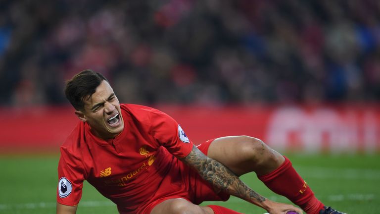 Liverpool's Brazilian midfielder Philippe Coutinho holds his foot as he lies on the pitch injured during the English Premier League football match between 