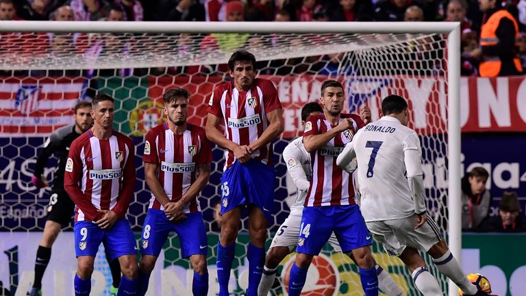Real Madrid's Portuguese forward Cristiano Ronaldo (R) shoots to score a goal during the Spanish league football match between Club Atletico de Madrid and 
