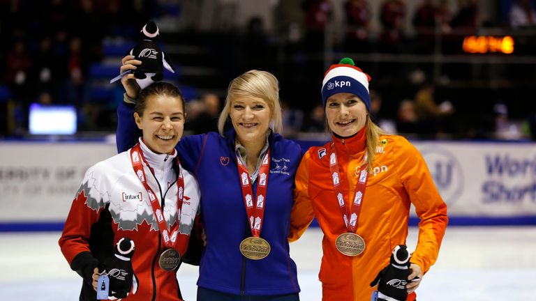 Elise Christie of Great Britain (C) celebrates her gold medal in the ladies 500m in Calgary alongside Jamie Macdonald (L) and Yara van Kerkhof (R) 