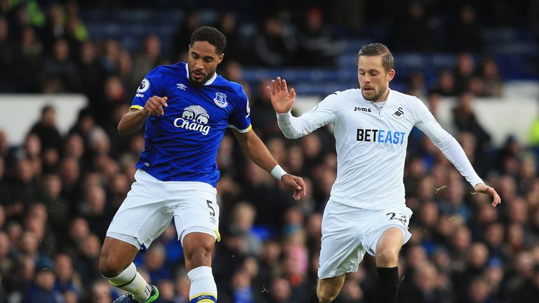 Ashley Williams of Everton (L) is put under pressure from Swansea's Gylfi Sigurdsson 