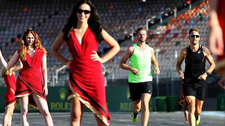 Jenson Button runs past the German GP grid girls as thet practice the night before race day - Picture from Getty Images