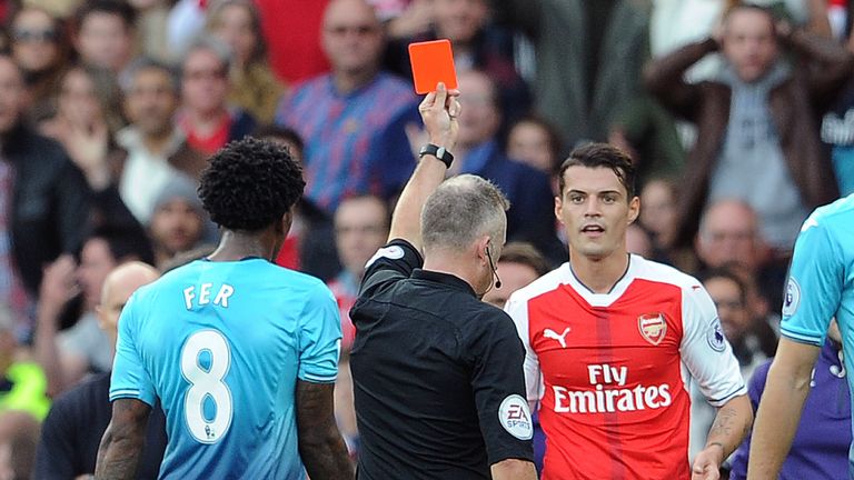 Referee Jon Moss shows the red card to Granit Xhaka  at the Emirates Stadium