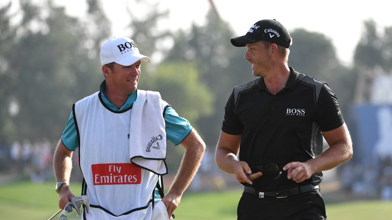 DUBAI, UNITED ARAB EMIRATES - NOVEMBER 20:  Henrik Stenson of Sweden walks off the 18th green with caddie Gareth Lord during day four of the DP World Tour 