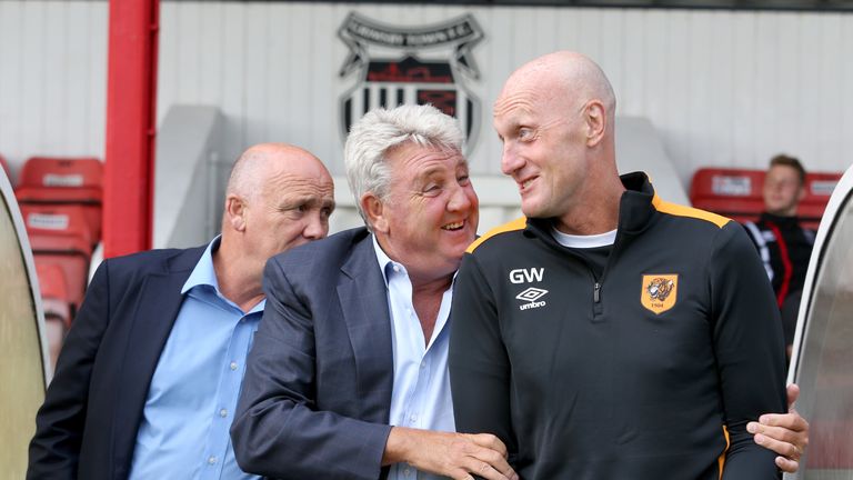 Hull City manager Steve Bruce (centre) and goalkeeping  coach Gary Walsh (right) share a joke as Mike Phelan looks on