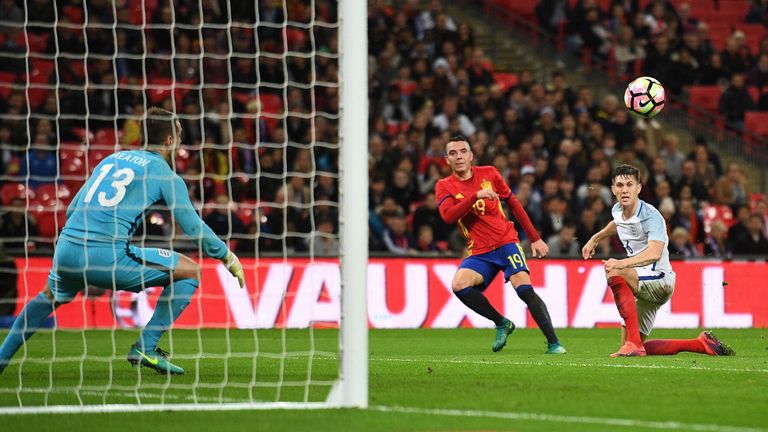Spain's forward Iago Aspas (C) shoots past England's defender John Stones (R) and England's goalkeeper Tom Heaton to score his team's first goal during the