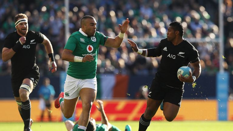 Waisake Naholo of New Zealand hands off Simon Zebo of Ireland 