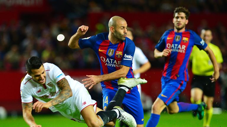 Sevilla's midfielder Vitolo (L) falls past Barcelona's Argentinian defender Javier Mascherano (C) during the Spanish league football match Sevilla FC vs FC