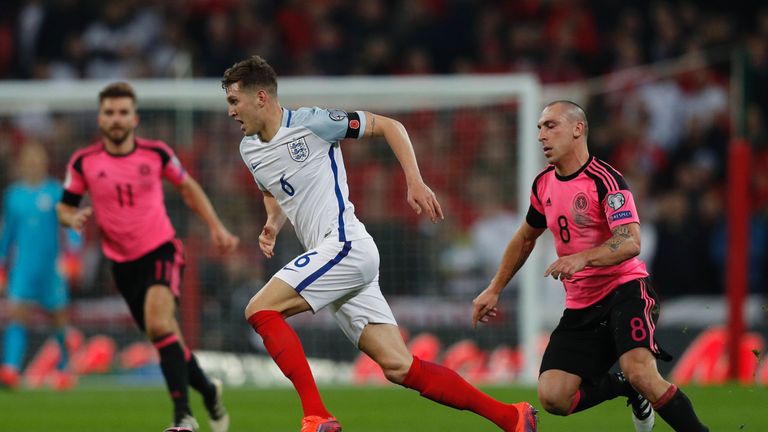 England's defender John Stones (C) runs past Scotland's midfielder Scott Brown during a World Cup 2018 qualification match between England and Scotland at 