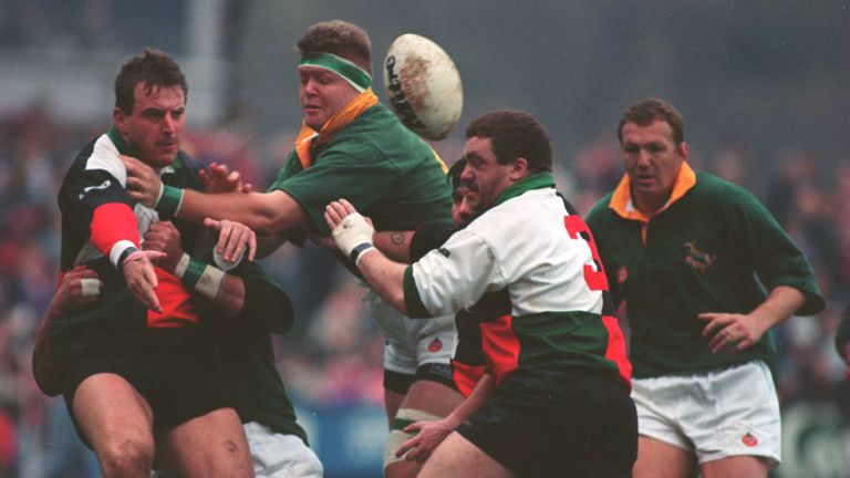 PHIL THOMAS OF PONTYPRIDD PASSES THE BALL AS SPRINGBOK KOBUS WIESE TACKLES DURING THEIR TOUR MATCH AT PONTYPRID, Nov 22 1994.