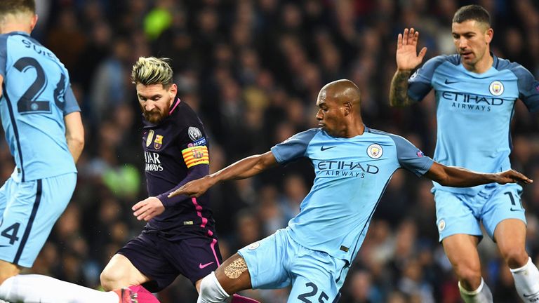 Manchester City midfielder Fernandinho (25) challenges Lionel Messi of Barcelona