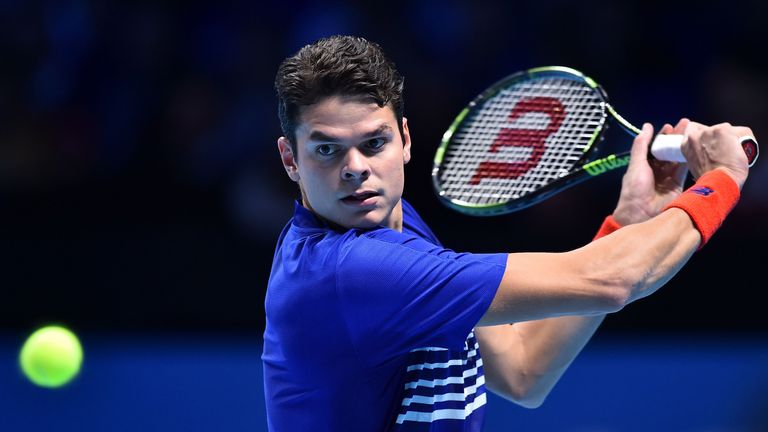 Milos Raonic hits a backhand return to Gael Monfils during their World Tour Finals match