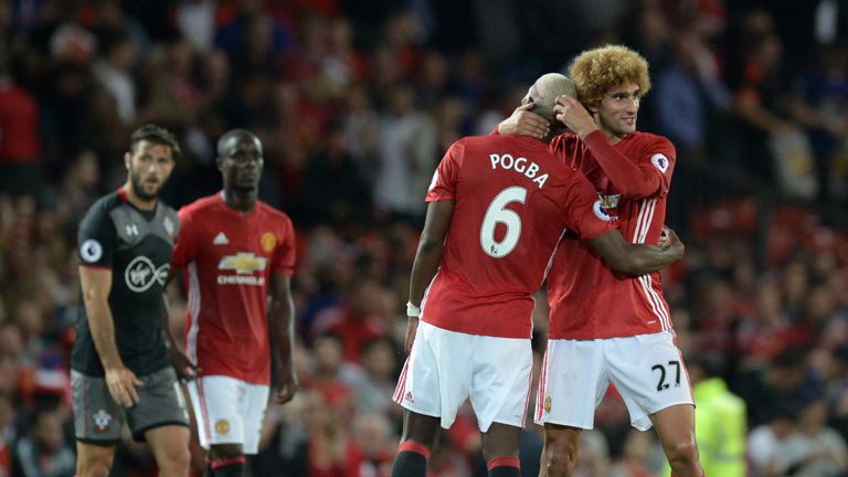 Manchester United's French midfielder Paul Pogba and Manchester United's Belgian midfielder Marouane Fellaini (R) celebrates on the pitch after the English