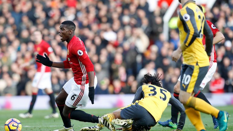 Paul Pogba goes down under the challenge of Mohamed Elneny