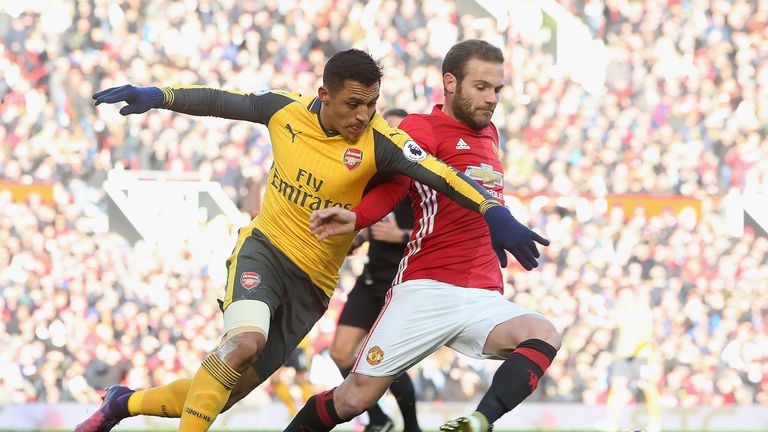 Juan Mata and Alexis Sanchez vie for possession of the ball
