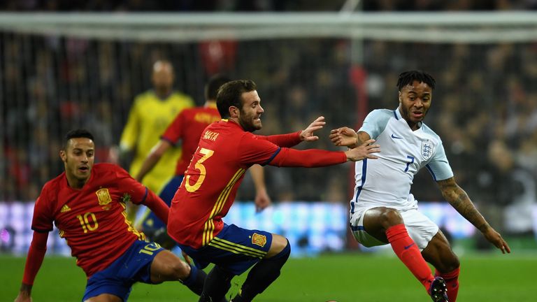 Raheem Sterling of England holds off pressure from Juan Mata of Spain during the international friendly match between England and Spain