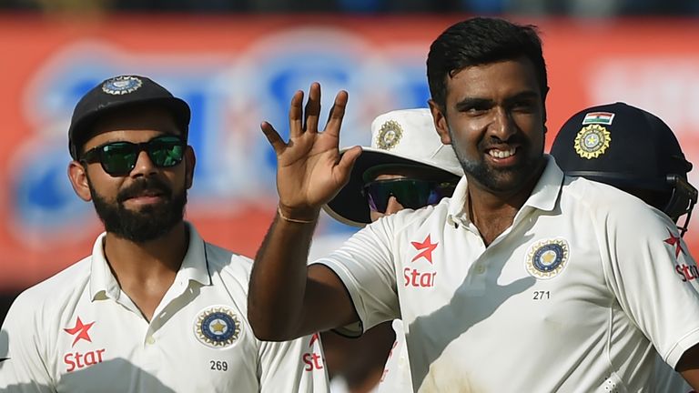 Indian bowler Ravichandran Ashwin (R) celebrates as captain Virat Kohli (L) watches after taking the wicket of New Zealand batsman Jeetan Patel during the 