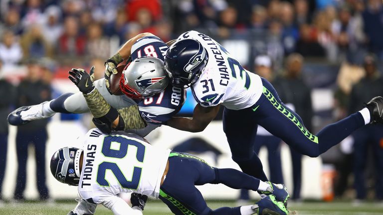 FOXBORO, MA - NOVEMBER 13: Rob Gronkowski #87 of the New England Patriots is tackled after making a catch by Earl Thomas #29 and Kam Chancellor #31 of the 