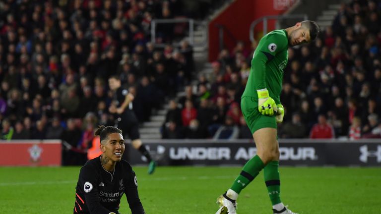 Southampton's English goalkeeper Fraser Forster (R) looks towards Liverpool's Brazilian midfielder Roberto Firmino after his failed attempt on goal during 