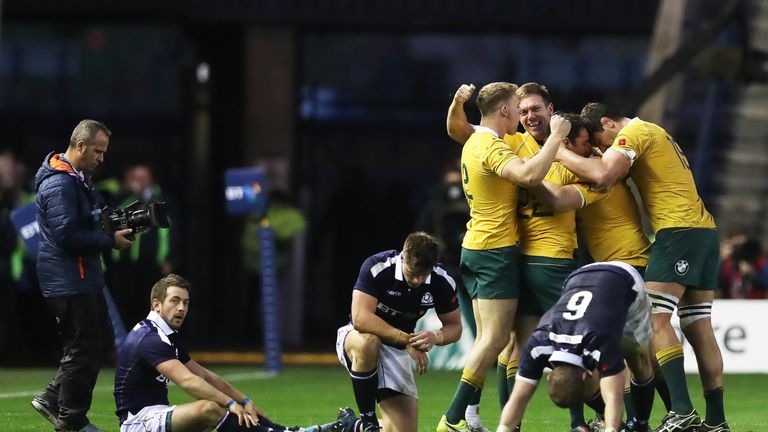 Greig Laidlaw (left) looks on as Australian players celebrate at the final whistle
