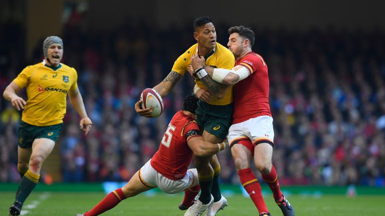 Israel Folau is tackled by Leigh Halfpenny and Alex Cuthbert of Wales