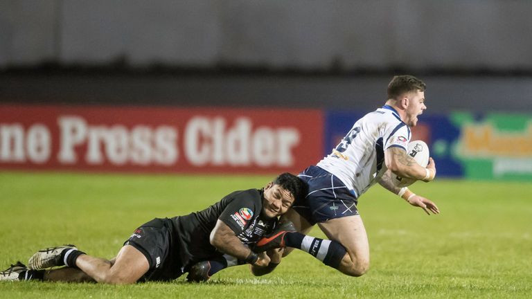 Issac Luke tackles Scotland's Liam Hood