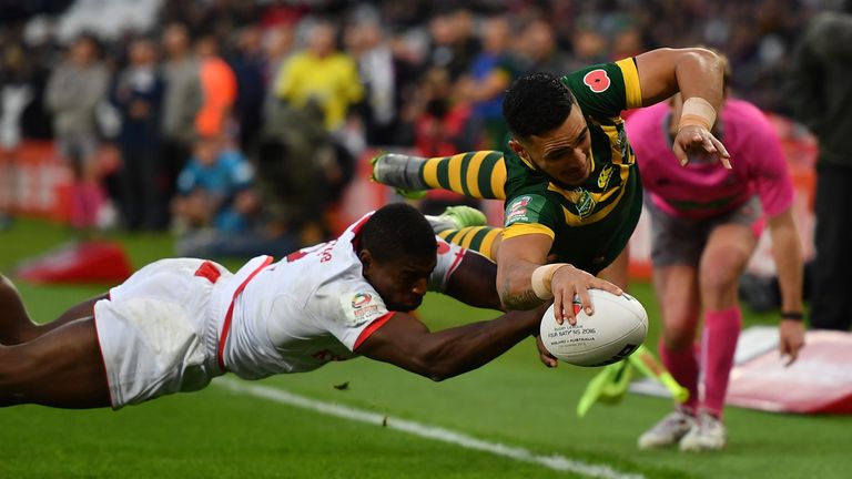 Valentine Holmes scores in the corner despite the efforts of Jermaine McGillvary of England