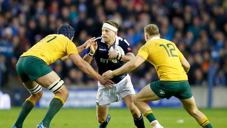 Scotland's Finn Russell takes on Australia's Dean Mumm (left) and Reece Hodge (right) 