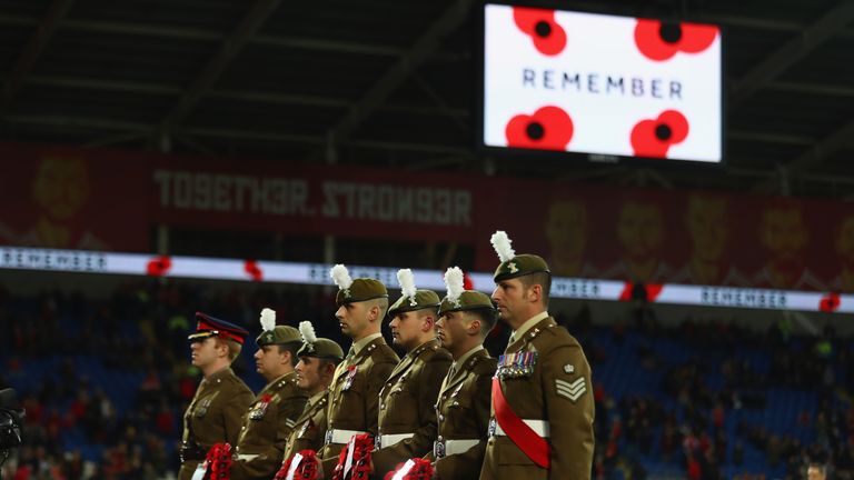 Soldiers hold poppy wreaths ahead of the teams entering the field of play during the FIFA 2018 World Cup Qualifier between Wales and Serbia