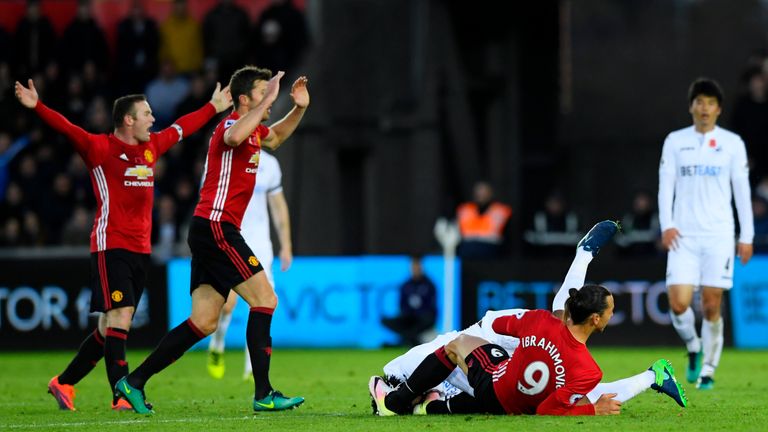 SWANSEA, WALES - NOVEMBER 06: Zlatan Ibrahimovic of Manchester United tackles Leroy Fer of Swansea City leading to a yellow card during the Premier League 