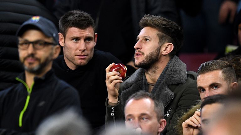 Adam Lallana eats an apple as he watches the game