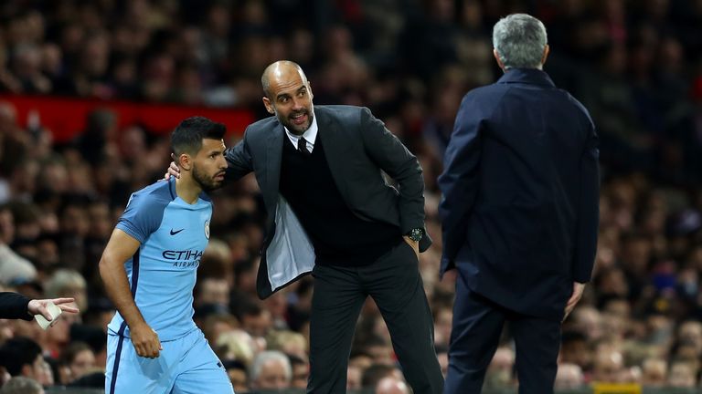 Sergio Aguero of Manchester City (L) prepares to come on while Josep Guardiola, Manager of Manchester City (R) gives him 