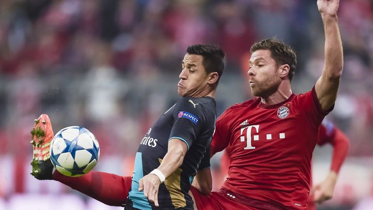 Alexis Sanchez holds off a challenge from Xabi Alonso at the Allianz Arena