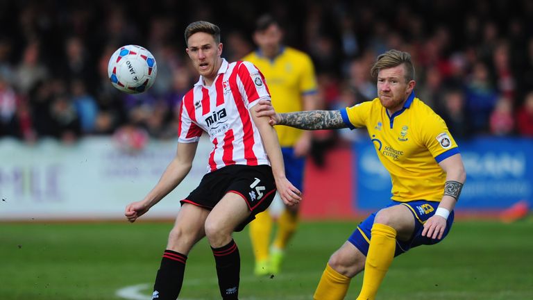 Asa Hall of Cheltenham Town is tackled by Alan Power of Lincoln City