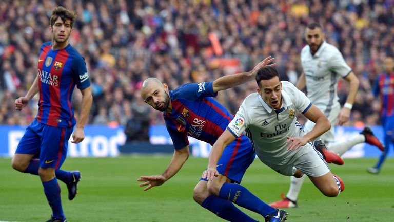 Real Madrid's midfielder Lucas Vazquez (R) vies with Barcelona's Argentinian defender Javier Mascherano (C) during the Spanish league football match FC Bar