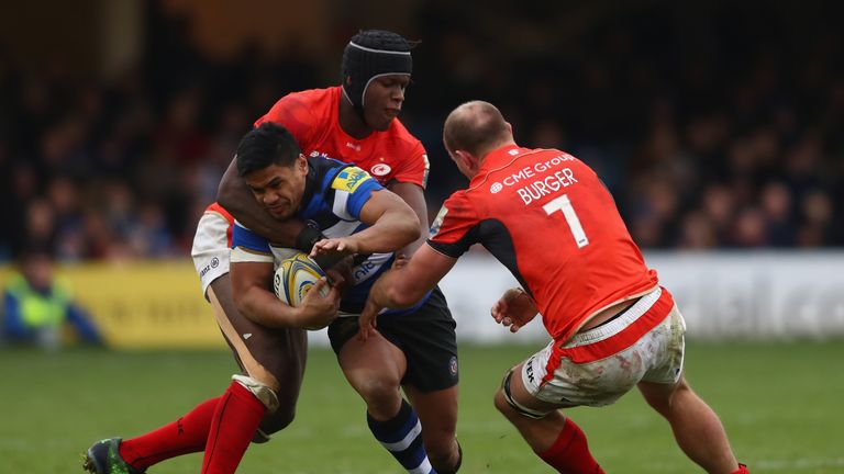 Ben Tapuai of Bath is held up by Maro Itoje (L) and Schalk Burger of Saracens 