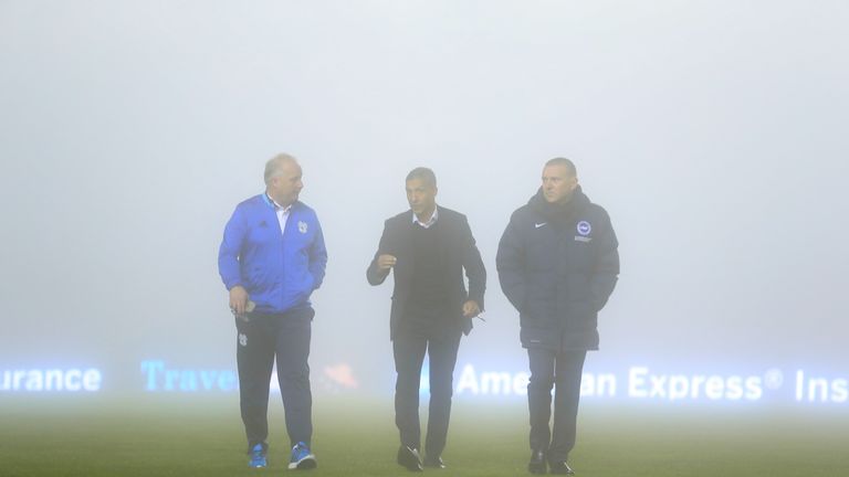 Brighton & Hove Albion manager Chris Hughton (centre) and Chief Executive Paul Barber (right) walk on the pitch in the fog ahead of the Sky Bet Championshi
