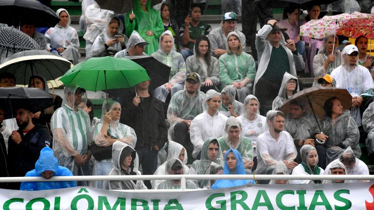 People attend under the rain the funeral of the members of the Chapecoense Real football club team killed in a plane crash in Colombia, at the stadium in  