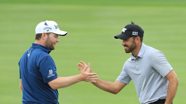 MALELANE, SOUTH AFRICA - DECEMBER 02:  Charl Schwartzel of South Africa (R) reacts with Branden Grace of South Africa (L) after holing a berdie put on the 