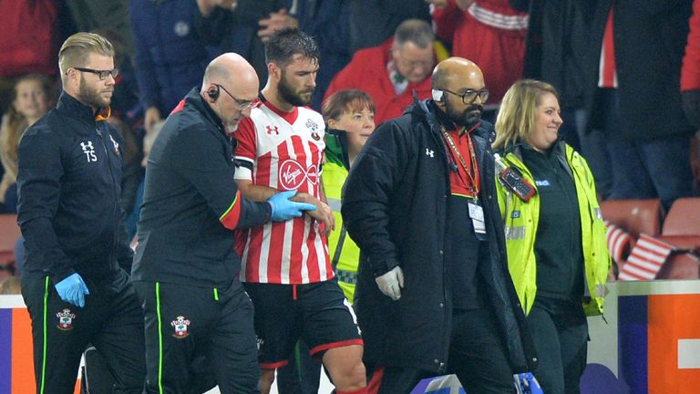 Southampton's English striker Charlie Austin (C) is helped from the pitch after picking up an injury after landing awkwardly during the UEFA Europa League 