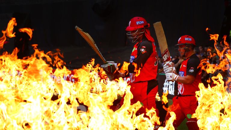 Chris Gayle and Aaron Finch of the Renegades walk through flames to open the batting during the Big Bash League