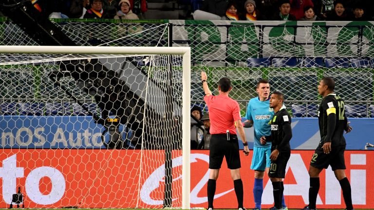 A referee (L) points to a penalty kick after speaking with the video assistant referee during the Club World Cup football semi-final match between Colombia
