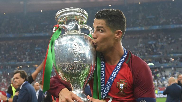 O atacante português Cristiano Ronaldo beija o troféu enquanto posa em campo depois que Portugal venceu a última partida de futebol do Euro 2016 entre Portugal e Portugal 