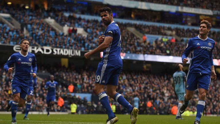 Chelsea's Brazilian-born Spanish striker Diego Costa points to his black armband as he celebrates scoring his team's first goal during the English Premier 