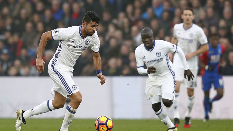 Chelsea's French midfielder N'Golo Kante (C) watches as Chelsea's Brazilian-born Spanish striker Diego Costa (L) runs with the ball during the English Prem